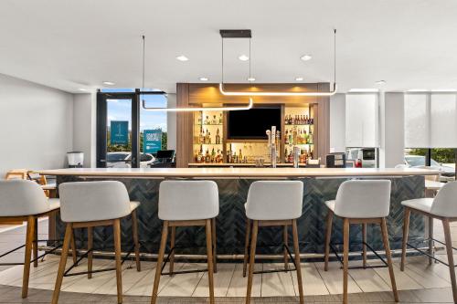 a bar with white bar stools in a room at Holiday Inn Austin North by IHG in Round Rock