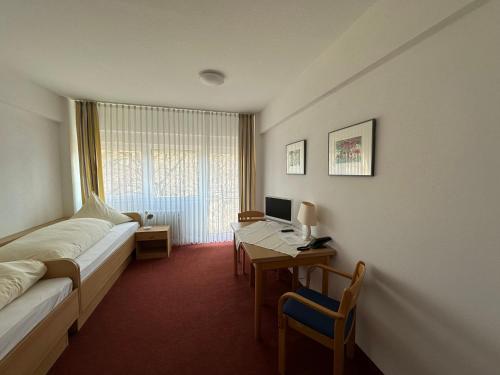 a room with a bed and a desk with a computer at GER-Haus in Waischenfeld