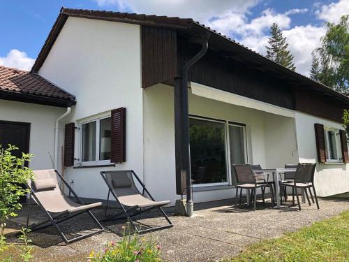 a group of chairs and a table in front of a house at Ferienhaus Fuchsweg im Feriendorf Reichenbach F17 in Nesselwang