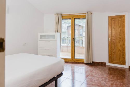 a white bedroom with a bed and a window at Ático para 12 personas con Vistas Panorámicas I AndBnB in Canillo