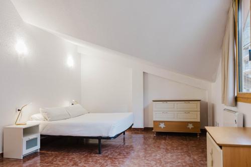 a white bedroom with a bed and a dresser at Ático para 12 personas con Vistas Panorámicas I AndBnB in Canillo