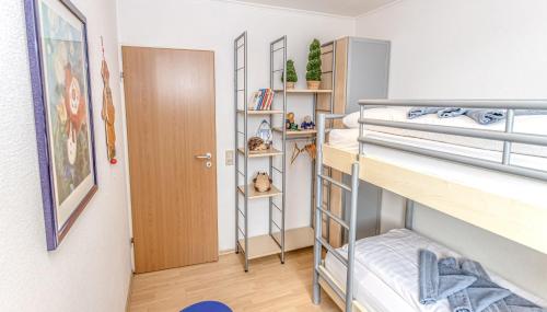 a room with two bunk beds and a door at Ferienhaus Möwennest in Bensersiel