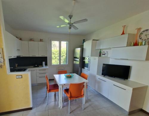 a kitchen with a table and a kitchen with white cabinets at Cristina in Caleri