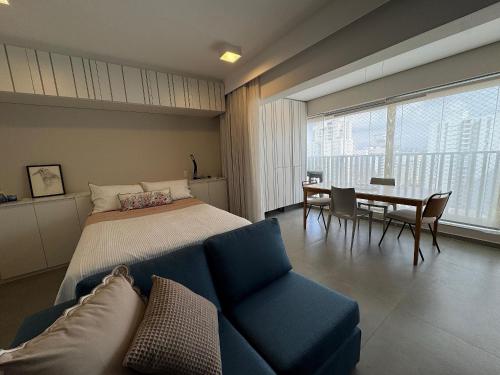a bedroom with a bed and a table and chairs at Edição Jardim Paulista in Sao Paulo