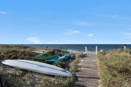 a group of kayaks on a beach near the water at Diana Luxury Retreat: Private Beach and Vineyards in Wading River