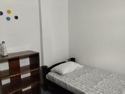 a small bedroom with a bed and a dresser at Hostal Paloma Café in Palomino