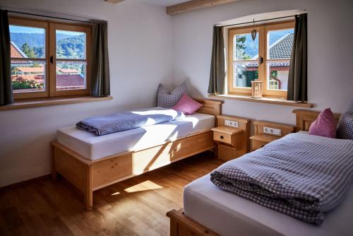 two beds in a room with two windows at Ferienwohnungen Bergbleamal in Rottach-Egern