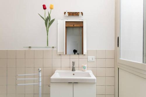 een witte badkamer met een wastafel en een spiegel bij Appartamenti Catania Centro in Catania