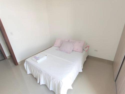 a small white bed with pink pillows on it at Espacio Confortable y Agradable, Atlantis in Santa Cruz de la Sierra