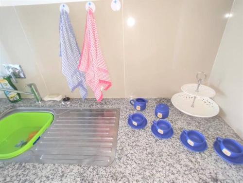 a kitchen counter with a sink and blue dishes on it at Espacio Confortable y Agradable, Atlantis in Santa Cruz de la Sierra