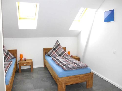 a attic room with two beds and skylights at Bed and Breakfast 