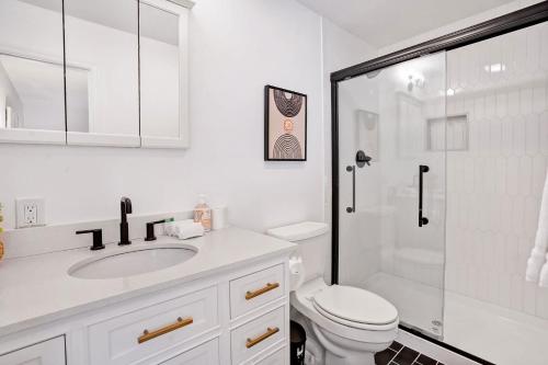 a white bathroom with a toilet and a shower at Respite Ranch: Private Pool, Hot Tub, Beach Access in Mattituck
