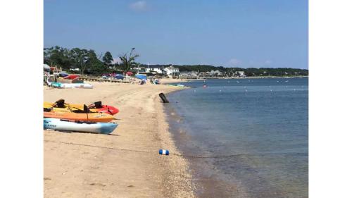 a beach with boats on the sand and the water at Respite Ranch: Private Pool, Hot Tub, Beach Access in Mattituck