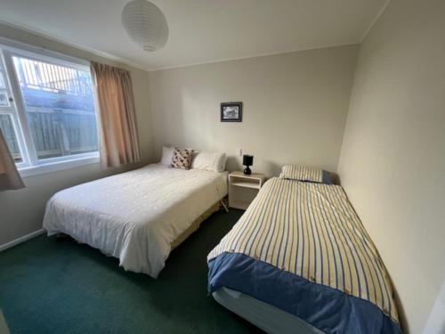 a bedroom with two beds and a window at Le Solterre - Akaroa Holiday Home in Akaroa