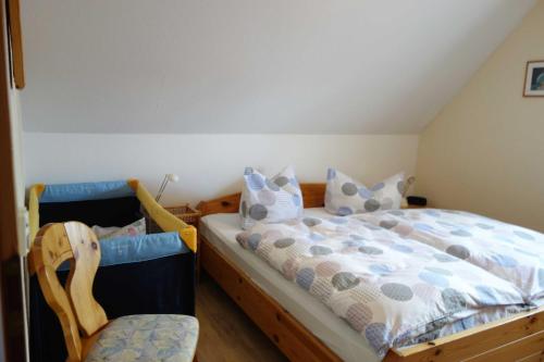 a bedroom with a bed and a chair at Ferienwohnung "Baum" in Rechlin