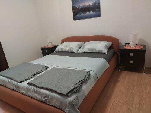a bedroom with a bed with two nightstands and two lamps at Sandra Apartmani 2 in Zaostrog