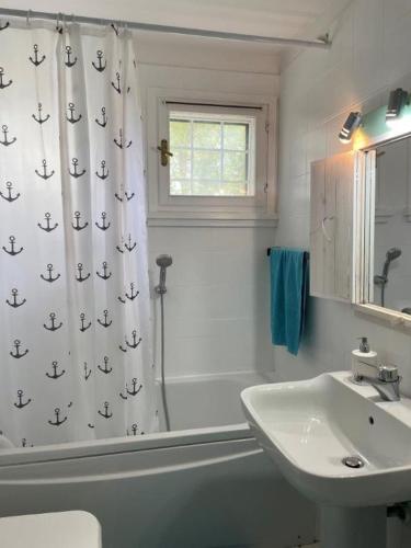 a bathroom with a sink and a shower curtain with anchors at Marittima in Palazzo Vianello