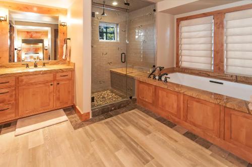 a bathroom with a large tub and a shower at West Lake Serenity with 180-Degree Lake Views in Homewood