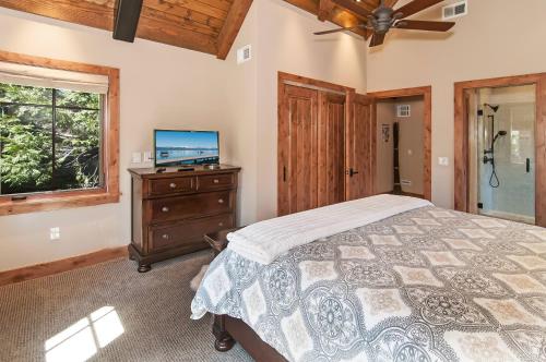 a bedroom with a bed and a tv and a window at West Lake Serenity with 180-Degree Lake Views in Homewood