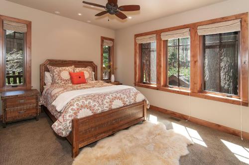 a bedroom with a bed and a fan and windows at West Lake Serenity with 180-Degree Lake Views in Homewood