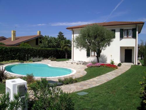a house and a swimming pool in a yard at D Oro in Caleri