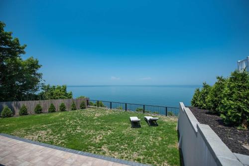 a yard with two chairs and the ocean in the background at Coastal Retreat: Waterfront, Deck, Awesome Views in Wading River