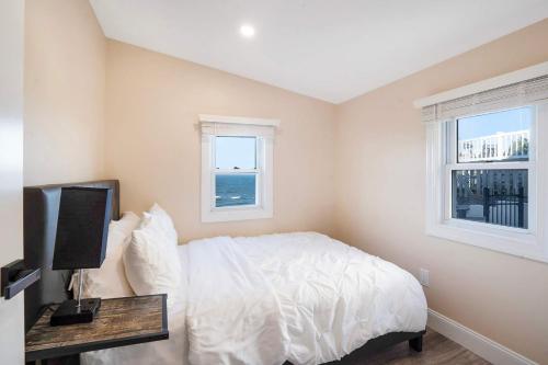 a bedroom with a bed and two windows at Coastal Retreat: Waterfront, Deck, Awesome Views in Wading River