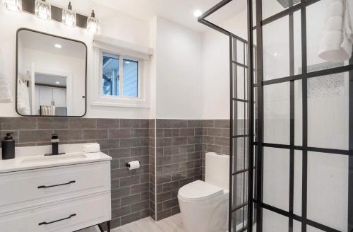 a bathroom with a toilet and a sink and a mirror at Coastal Retreat: Waterfront, Deck, Awesome Views in Wading River