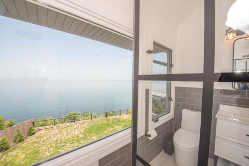 a bathroom with a large window with a view of the water at Coastal Retreat: Waterfront, Deck, Awesome Views in Wading River