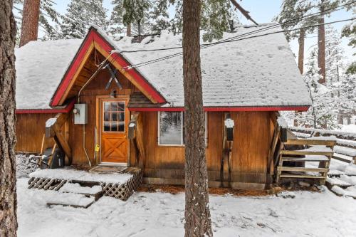 a wooden cabin with a red roof in the snow at West Shore Haven - Near Beach & Outdoor Fun in Tahoma