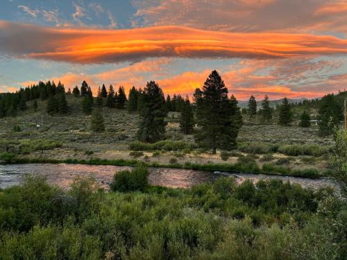 a sunset over a river in a field with trees at West Shore Haven - Near Beach & Outdoor Fun in Tahoma