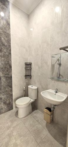 a bathroom with a toilet and a sink at Ease Living Palem Kenari in Jatirarangan