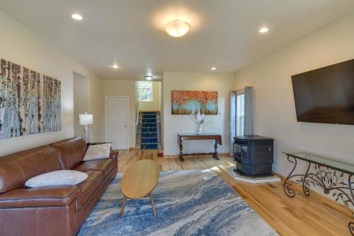 a living room with a leather couch and a wood stove at Mountain-View Conifer Gem Near Hiking and Fishing in Conifer