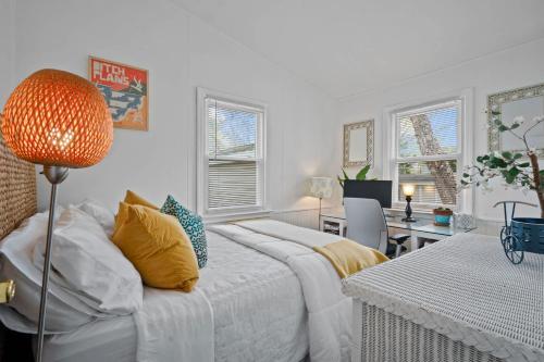 a bedroom with a bed and a table and a desk at Sea Cliff Charm: 5 Mins to Beach, Firepit in Wading River