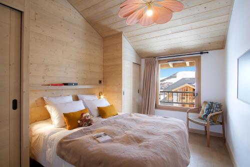 une chambre avec un lit dans une pièce avec une fenêtre dans l'établissement Résidence Phoenix B by Leavetown Vacations, à L'Alpe-d'Huez