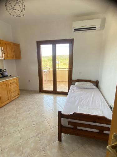 Un dormitorio con una cama y una puerta corrediza de vidrio. en Aphrodites Gardens 2, en Ormos Panagias