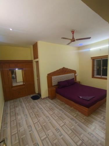 a bedroom with a bed and a ceiling fan at Yal Homestay in Yercaud
