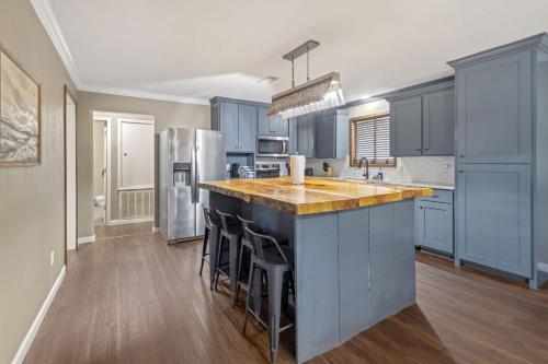 a kitchen with blue cabinets and a large island with bar stools at Modern Rustic Family Home in Westlake La in Westlake