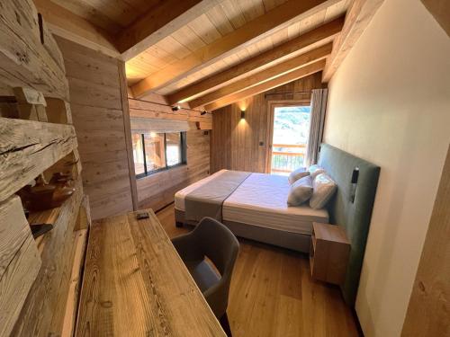 a bedroom with a bed and a table in a room at Chalet Les 3 Ours by Leavetown Vacations in Les Deux Alpes