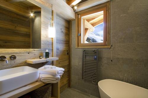 a bathroom with a sink and a toilet and a mirror at Chalet Les 3 Ours by Leavetown Vacations in Les Deux Alpes