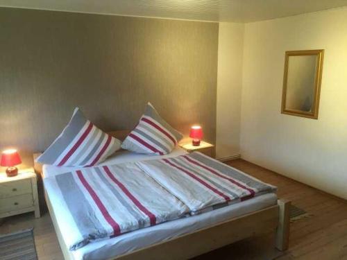a bedroom with a bed with a red candle on two tables at Ferienwohnungen Falkenhagen in Dörpstedt
