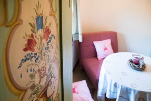 a small room with a pink couch and a table at Gästehaus Becher, Kreuth-Point in Kreuth