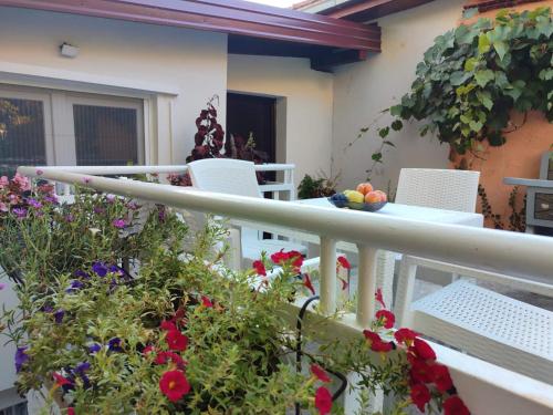 a balcony with a table and chairs and flowers at Apartmani Adi in Mostar