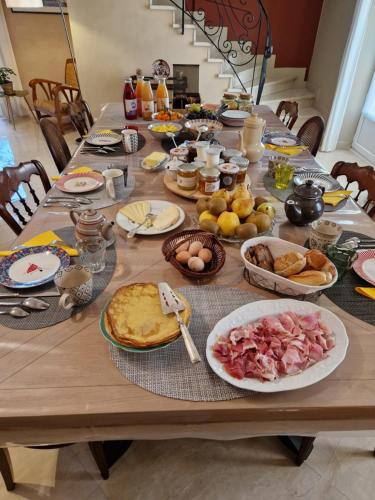 een houten tafel met eten erop bij Au Clos du Bourg in Blasimon