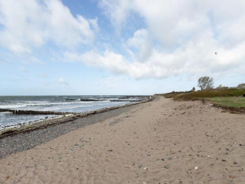 a sandy beach next to the ocean on a cloudy day at Ferienwohnung Kranich - Dranske in Dranske