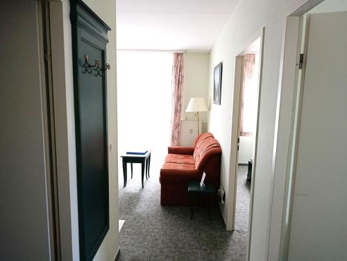 ein Wohnzimmer mit einem roten Sofa und einem Tisch in der Unterkunft Fewo Rosenhof 02 in Kühlungsborn