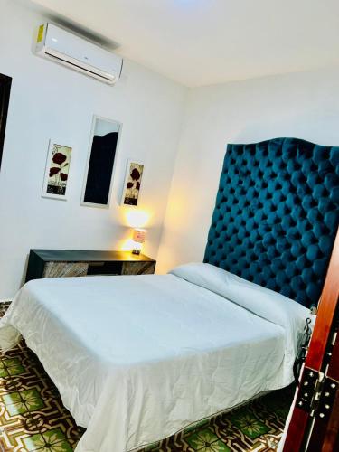 a bedroom with a large bed with a blue headboard at Hotel Boutique Doña Celia in Aguascalientes