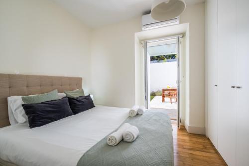 a bedroom with a large bed with towels on it at Dom Vasco 30 - Charm flat with garden by Belém in Lisbon