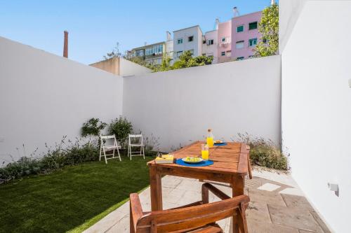 a patio with a wooden table and chairs at Dom Vasco 30 - Charm flat with garden by Belém in Lisbon
