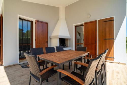 une salle à manger avec une table et des chaises en bois dans l'établissement Leccio, à Albarella